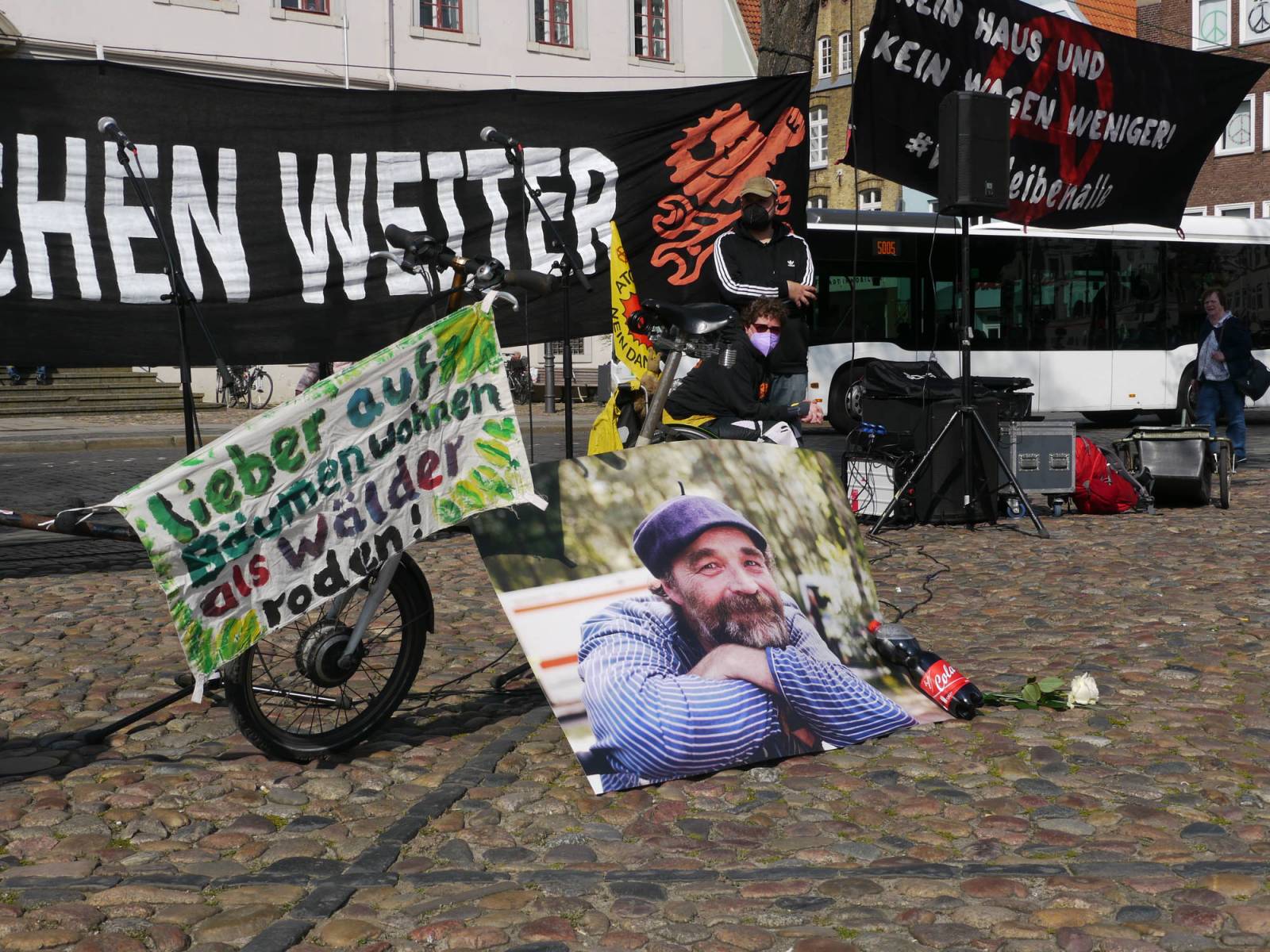 Banner "Wor machen Weiter", foto von Karsten, sein Fahrrad, Cola Flasche, Banner "lieber in den Bäumen wohen als Wälder roden"